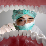 یک دندانپزشک در حال معاینه مدل دهان و دندان‌ها